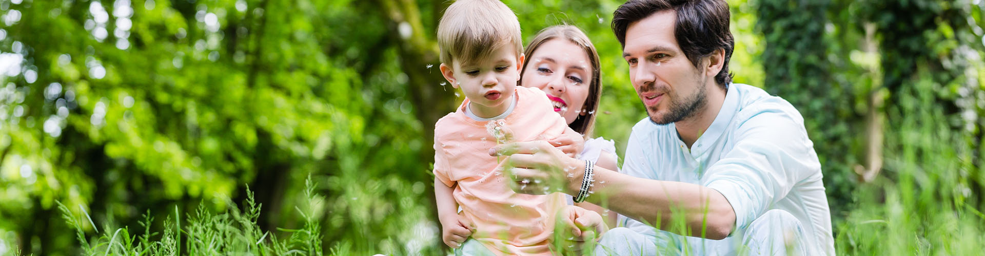 family playing outside with a dandelion flower
